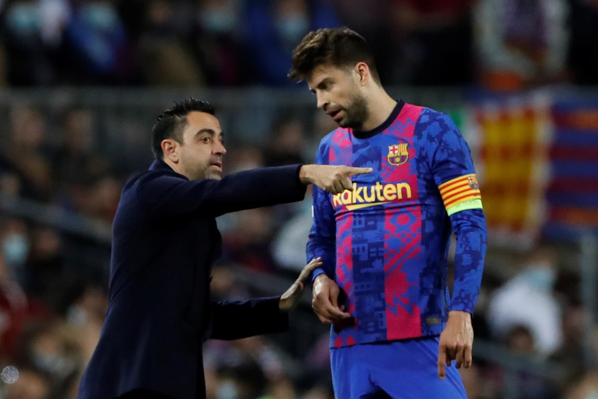 El entrenador del Barcelona Xavi Hernández (i) da instrucciones a su jugador y capitán, el defensa Gerard Piqué en el Camp Nou en Barcelona en foto de archivo de Alberto Estévez