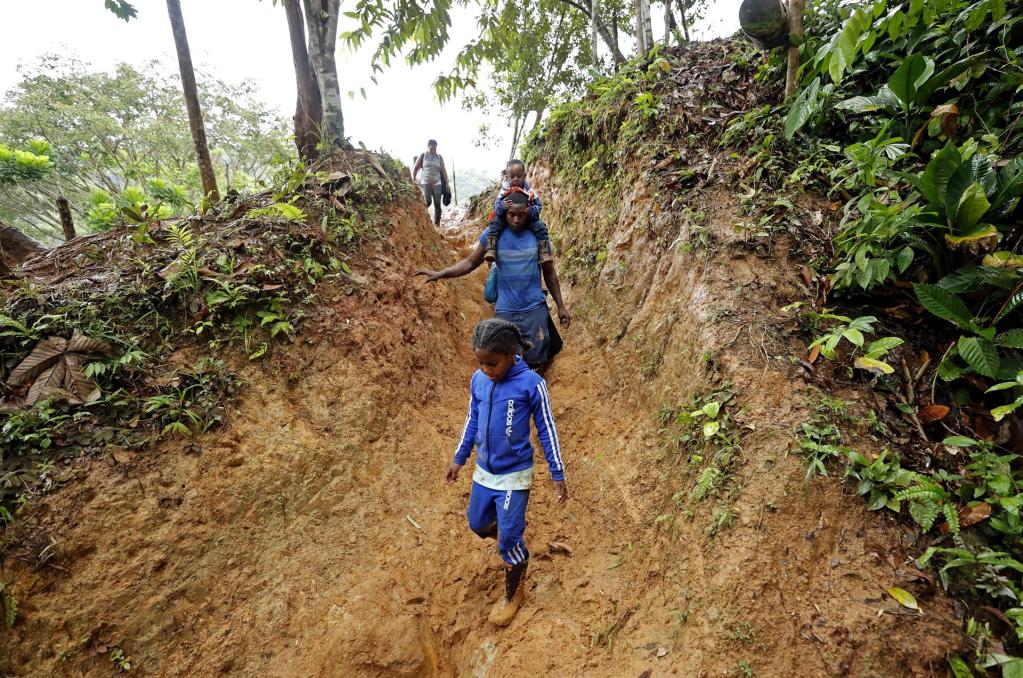 Un padre y sus hijos caminan por una montaña con la intención de llegar a Panamá, el 8 de octubre de 2022, a través del Tapón del Darién (Colombia). EFE/Mauricio Dueñas Castañeda
