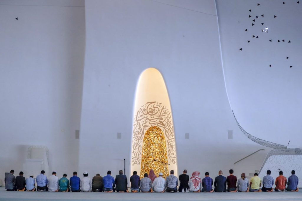 Un grupo de personas de espaldas reza en la Mezquita Education City