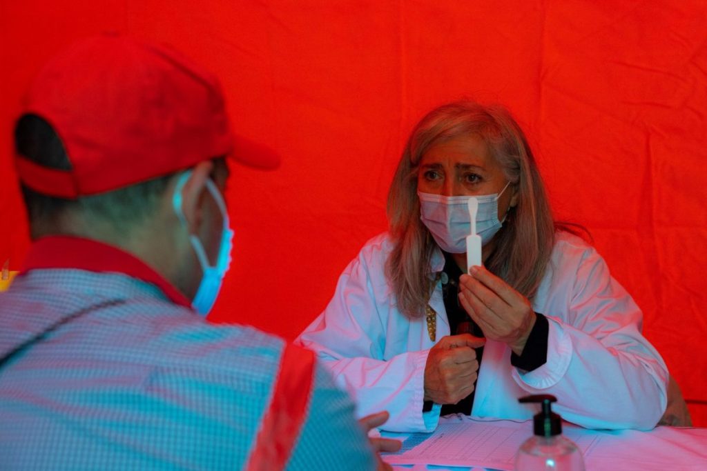 Una persona atiende a las indicaciones de una sanitaria para realizarse una prueba de VIH