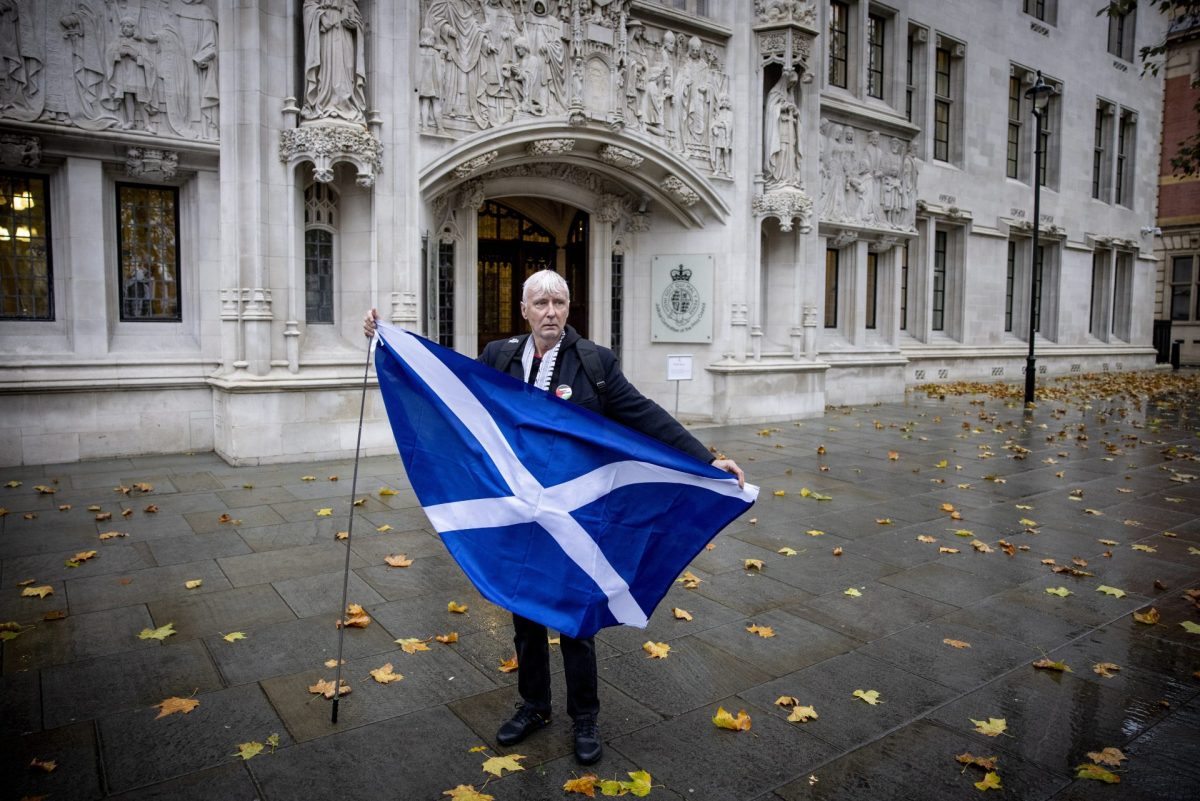 Un activista pro-referendum sostiene una bandera escocesa frente a la Corte Suprema del Reino Unido en Londres, este miércoles, 23 de noviembre
