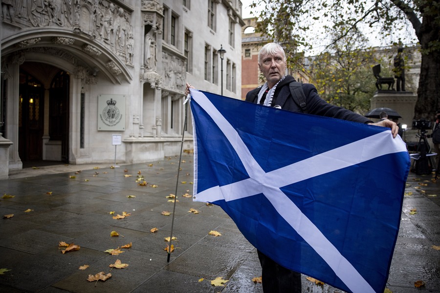 A man holding a Scottish flag