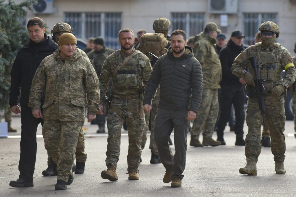 El presidente ucraniano Volodymyr Zelensky (4-i, frente) a su llegada a la recuperada ciudad de Jersón, acompañado de altos mandos militares