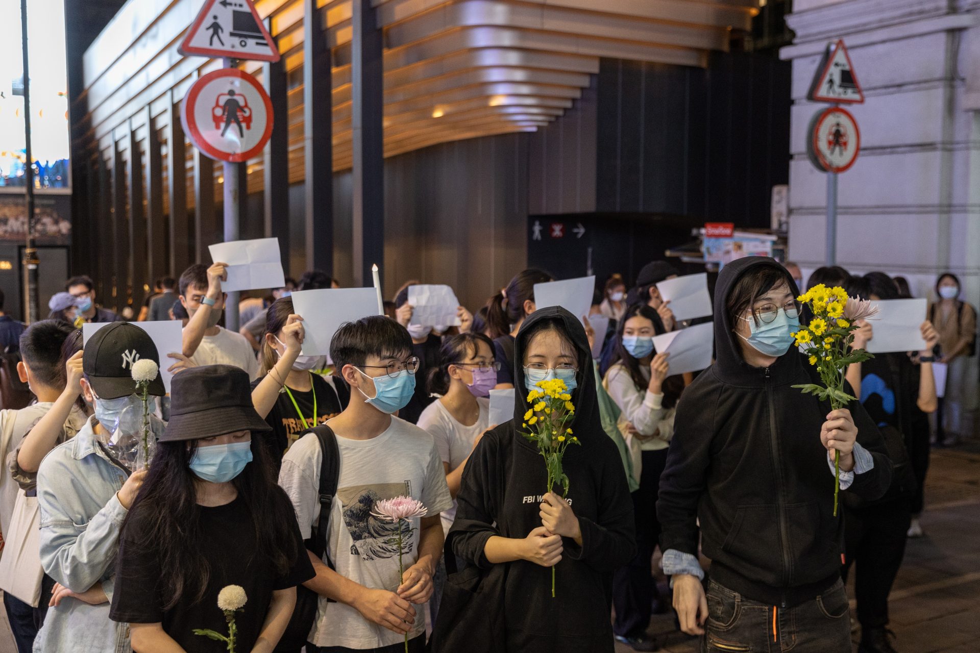 Varias personas hacen vigilia por las víctimas de las políticas China de Covid Cero y por las víctimas del incendio de Urumqi en Hong Kong, China.