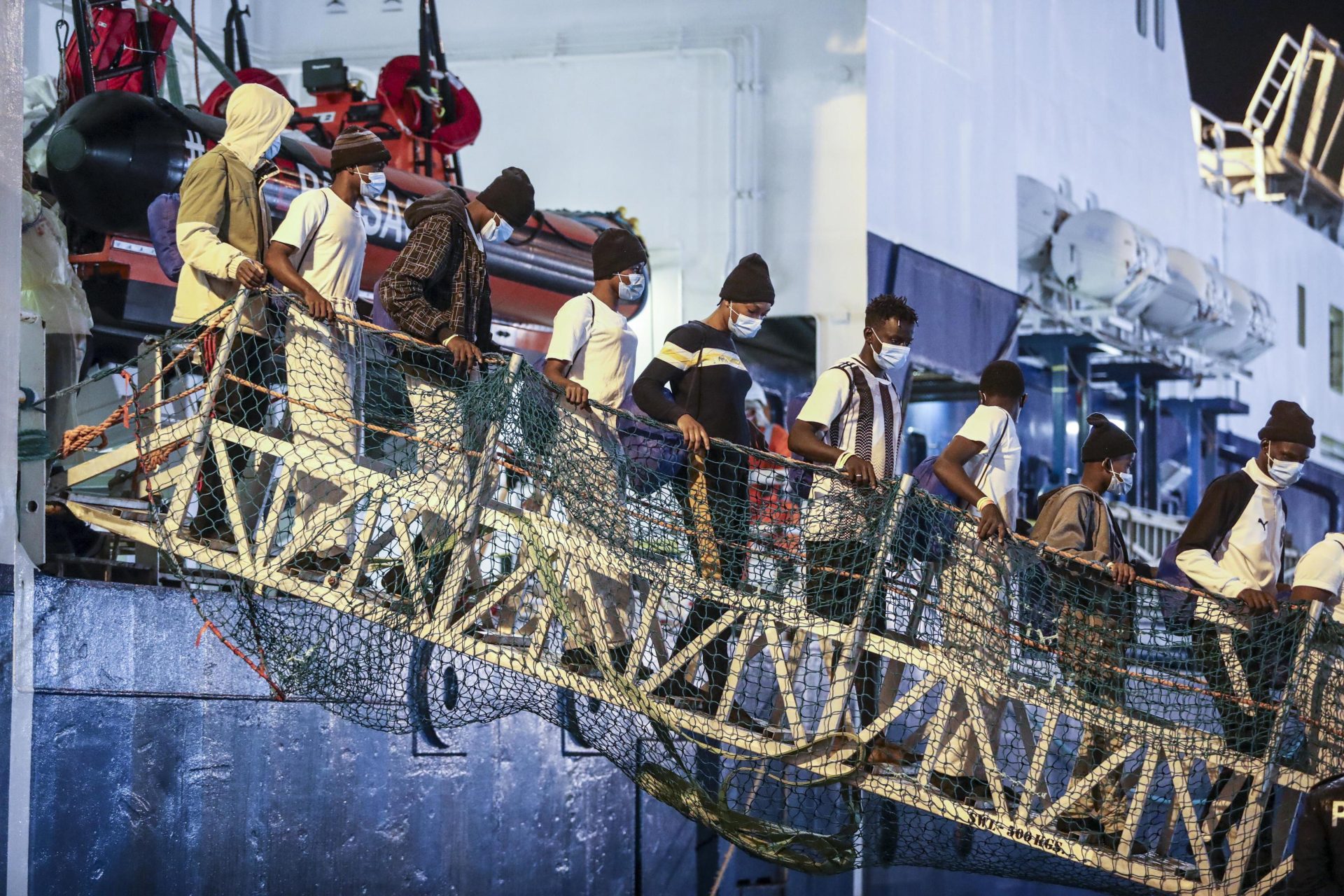 Inmigrantes rescatados del mar mediterráneo bajan del barco Geo Barents, de la ONG Médicos Sin Fronteras.