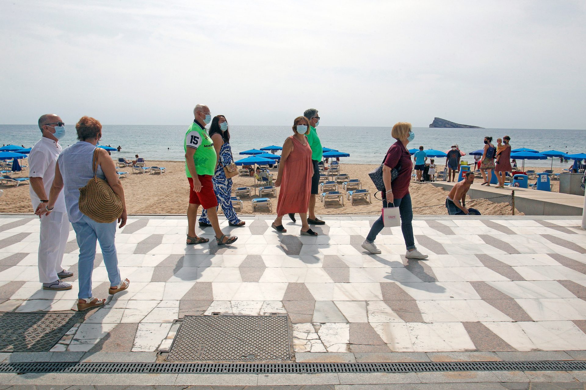 Un grupo de turistas pasean por la playa de Benidorm