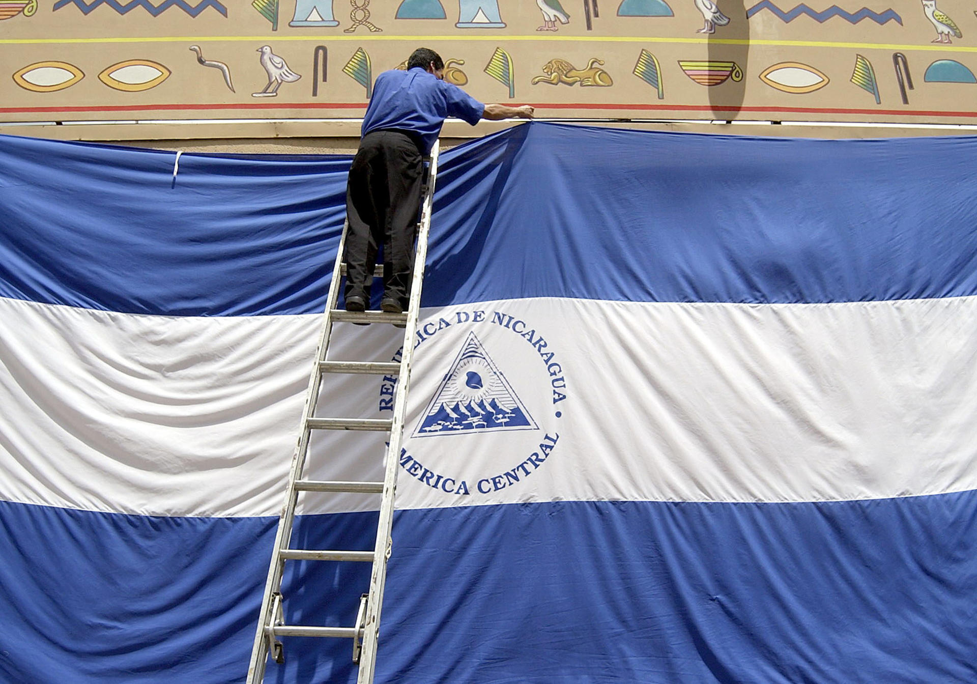 Un empleado del Casino Pharaos de Managua instala una bandera gigante de Nicaragua con motivo de la celebración del 182 Aniversario de la Independencia. EFE/Archivo/Oscar Navarrete