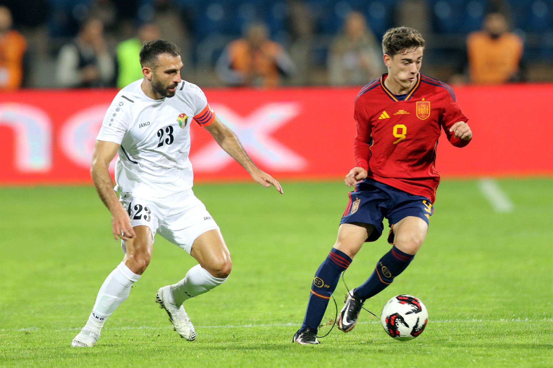 Ehsan Haddad de Jordania (i) en acción contra Gavi de España (d) durante el partido amistoso de fútbol internacional entre Jordania y España.