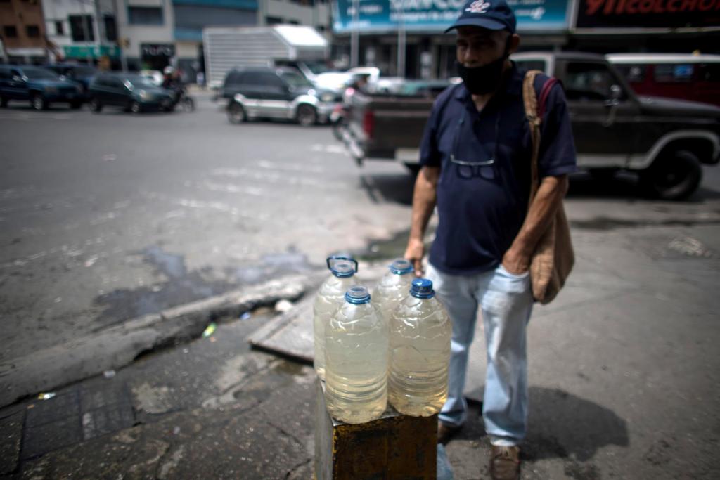 Un hombre recoge agua de una tubería callejera, el 26 de octubre de 2022, en Caracas (Venezuela). EFE/ Miguel Gutierrez