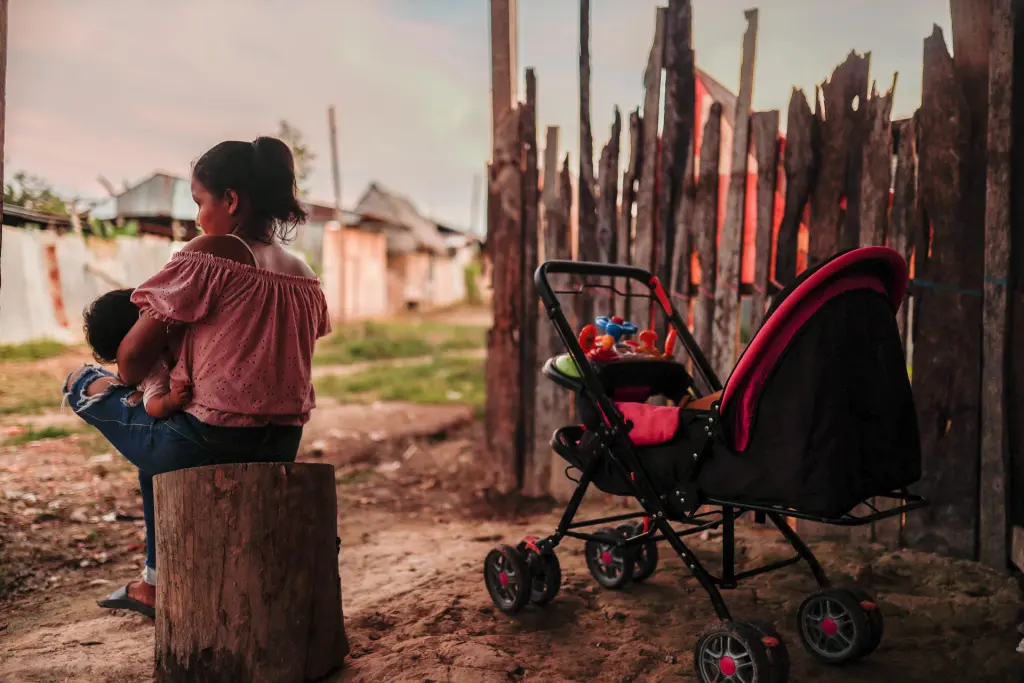 Elita se sienta afuera de su hogar para darle de lactar a su bebé, el 23 de noviembre de 2022, en Iquitos (Perú). EFE/ Aldair Mejía
