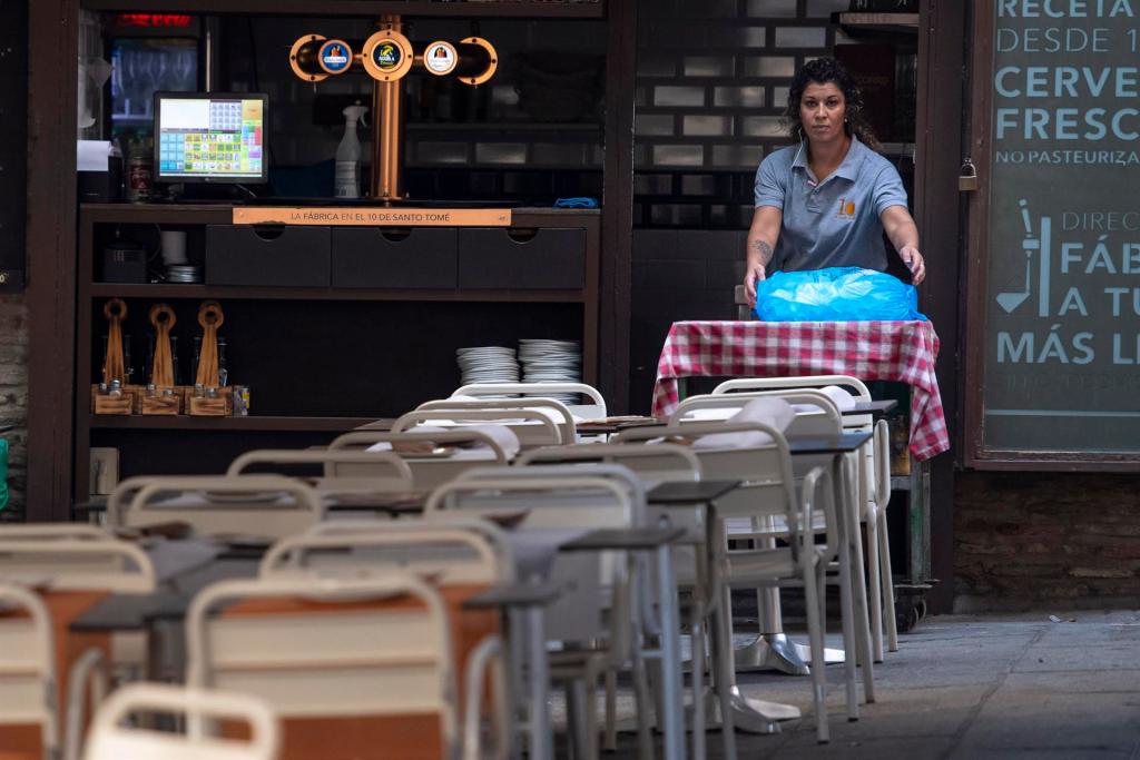 Una camarera coloca las mesa en un bar. EFE/Ismael Herrero/Archivo
