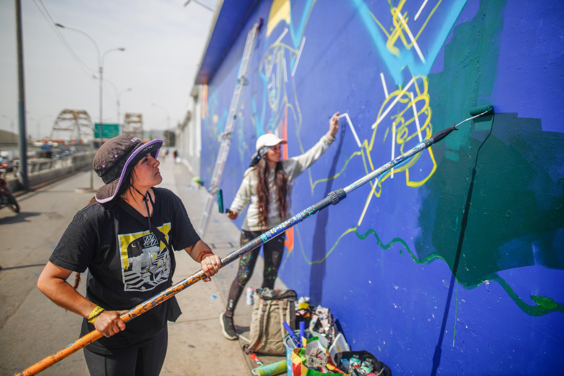 Araceli Villarreal y Meki pintan unos de los murales ubicado en la Avenida Alfonso Ugarte, en Lima (Perú). EFE/ Aldair Mejia