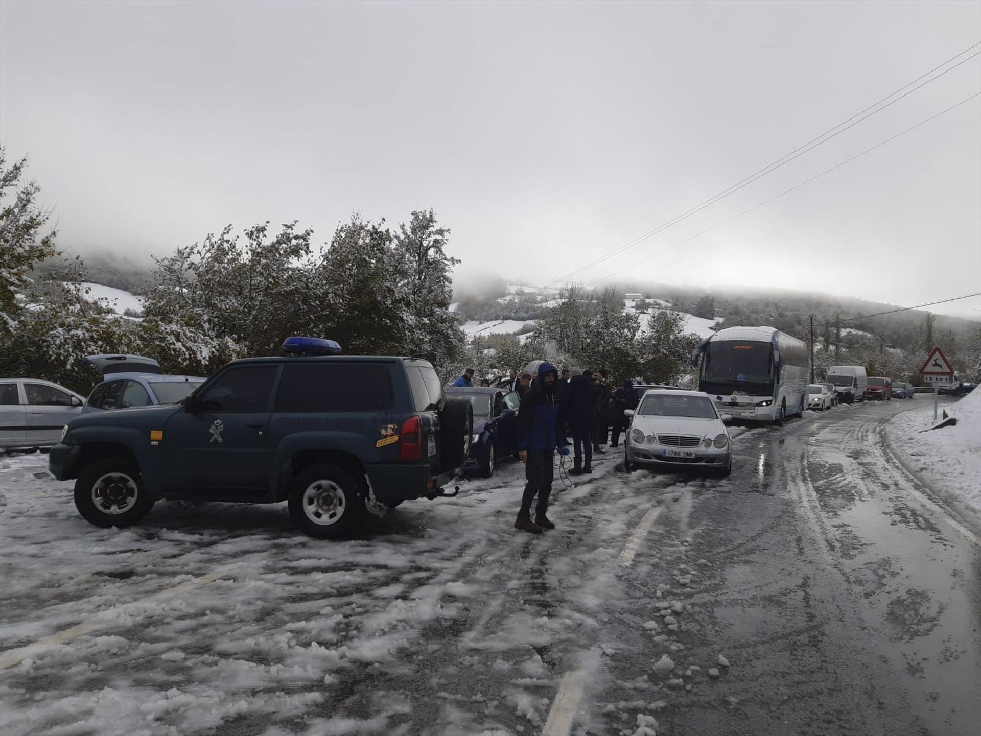 La Guardia civil auxilia a un autobús y los vehículos que acudían a una boda en Roncesvalles tras quedarse bloqueados por la nieve en la N135, este sábado en el Alto de Mezkiritz. EFE/ Guardia Civil SÓLO USO EDITORIAL / SÓLO DISPONIBLE PARA ILUSTRAR LA NOTICIA QUE ACOMPAÑA (CRÉDITO OBLIGATORIO)