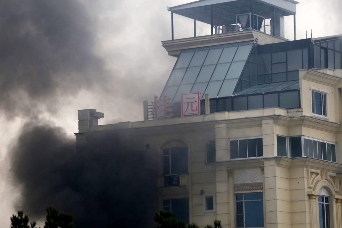 Una columna de humo sale de la fachada del hotel de Kabul, atacado este lunes.