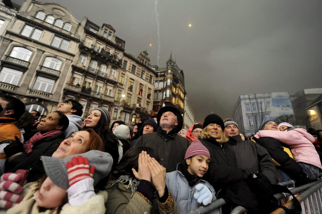 Varias personas miraban al cielo para ver el espectáculo de fuegos artificiales organizado para recibir al nuevo año en el Mont des Arts/Kunstberg en Bruselas (Bélgica)