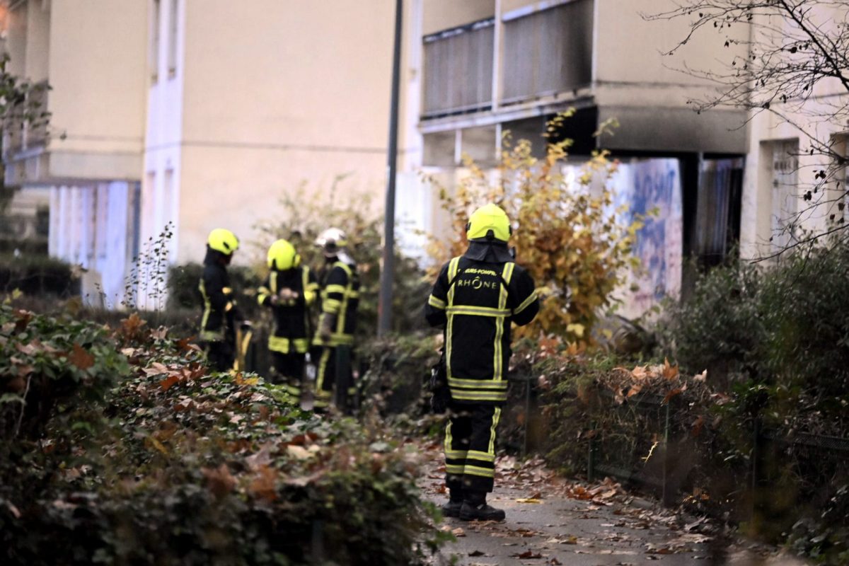 Una dotación de bomberos trabaja en el edificio de apartamentos de Vaulx-en-Velin, en las afueras de Lyon, que se ha incendiado esta madrugada.
