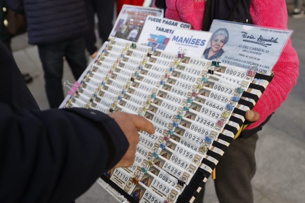 Una lotera vende décimos de Lotería para el sorteo navideño de El Gordo en la Puerta del Sol de Madrid.