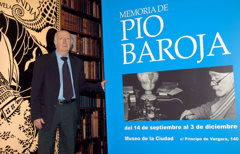 Pío Caro Baroja, sobrino de Pío Baroja, posaba junto al cartel de la exposición organizada en Madrid con motivo del cincuentenario de la  muerte del escritor, en 2006.