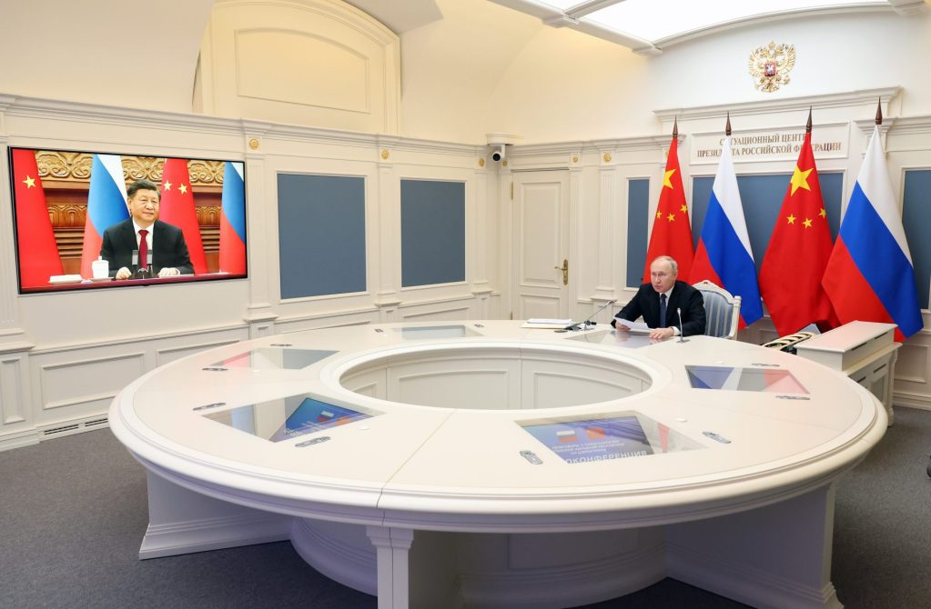 El presidente ruso, Vladimir Putin (d), en la reunión que ha mantenido esta mañana en el Kremlin con el presidente chino, Xi Jinping (en pantalla) por videoconferencia. 