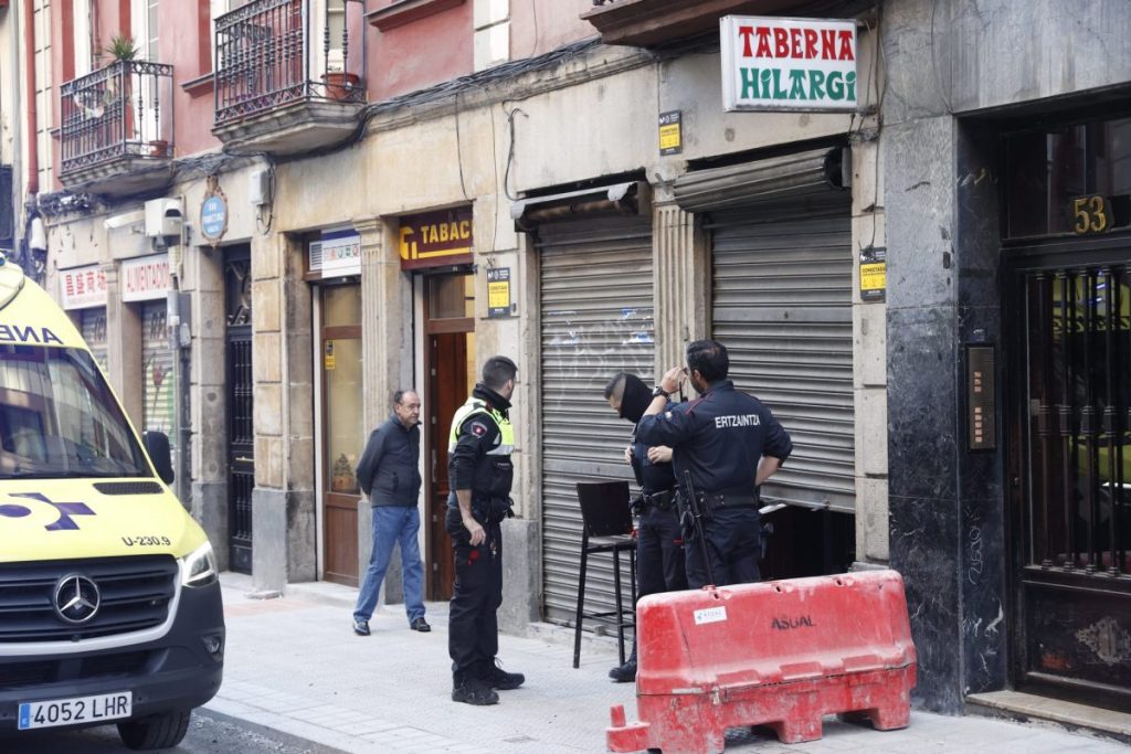 Agentes de la Ertzaintza inspeccionan un bar en Bilbao en el que una mujer ha sido asesinada por su pareja.