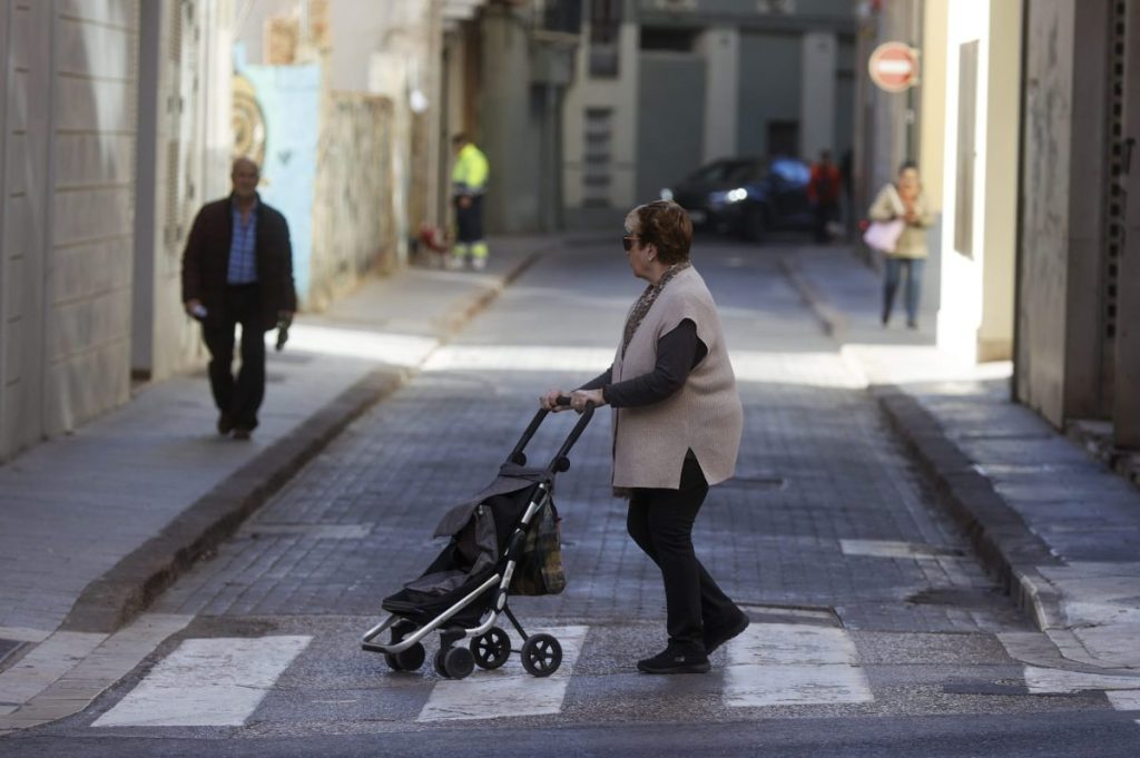 Una mujer empuja su carro de la compra camino del mercado, hoy en Valencia.
