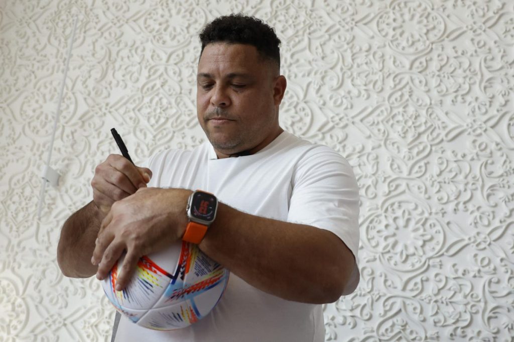 Ronaldo Nazario, leyenda del fútbol brasileño, firma un balón tras la rueda de prensa ofrecida el lunes en Doha. 