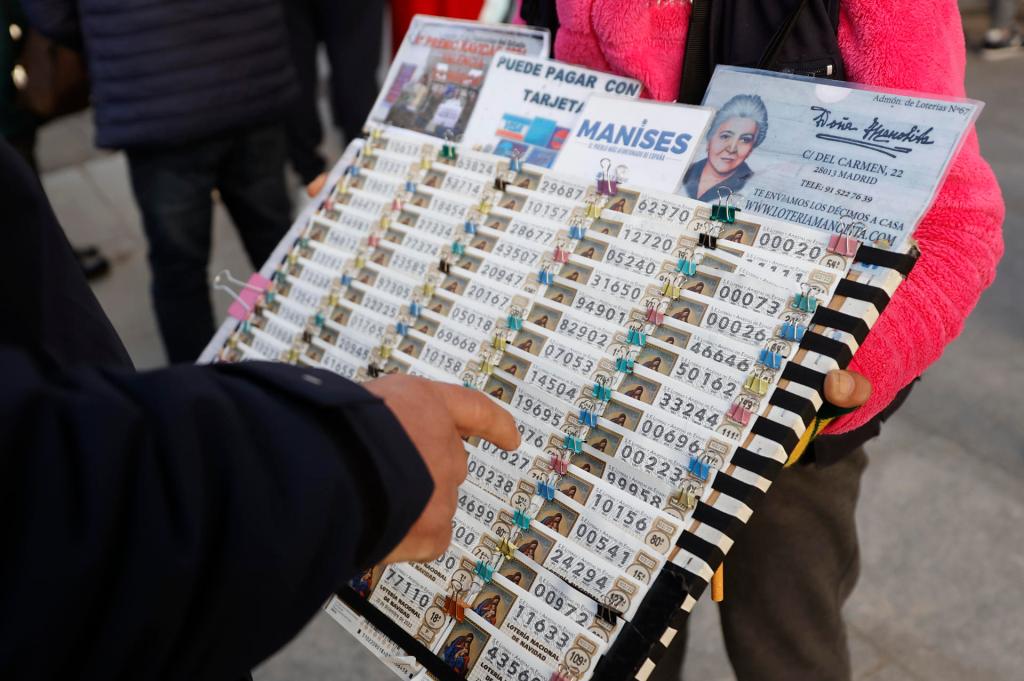Una lotera vende décimos de Lotería para el sorteo navideño de El Gordo en la Puerta del Sol de Madrid. EFE/ Mariscal
