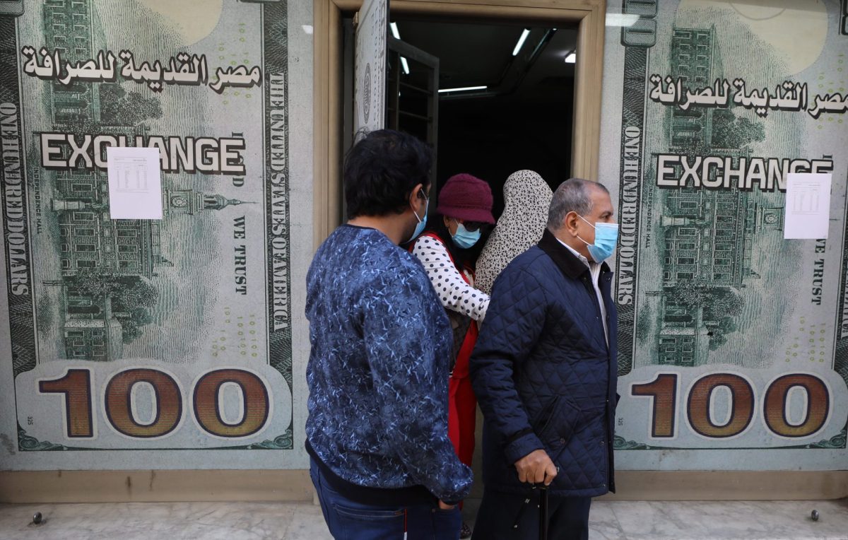 Egipcios caminando junto a una oficina de cambio de moneda en El Cairo