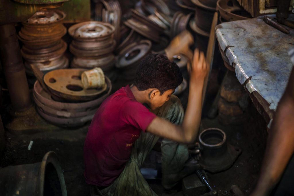 Imagen de archivo de un niño trabajando en un mercado de piezas de vehículo de segunda mano en Calcuta (India)