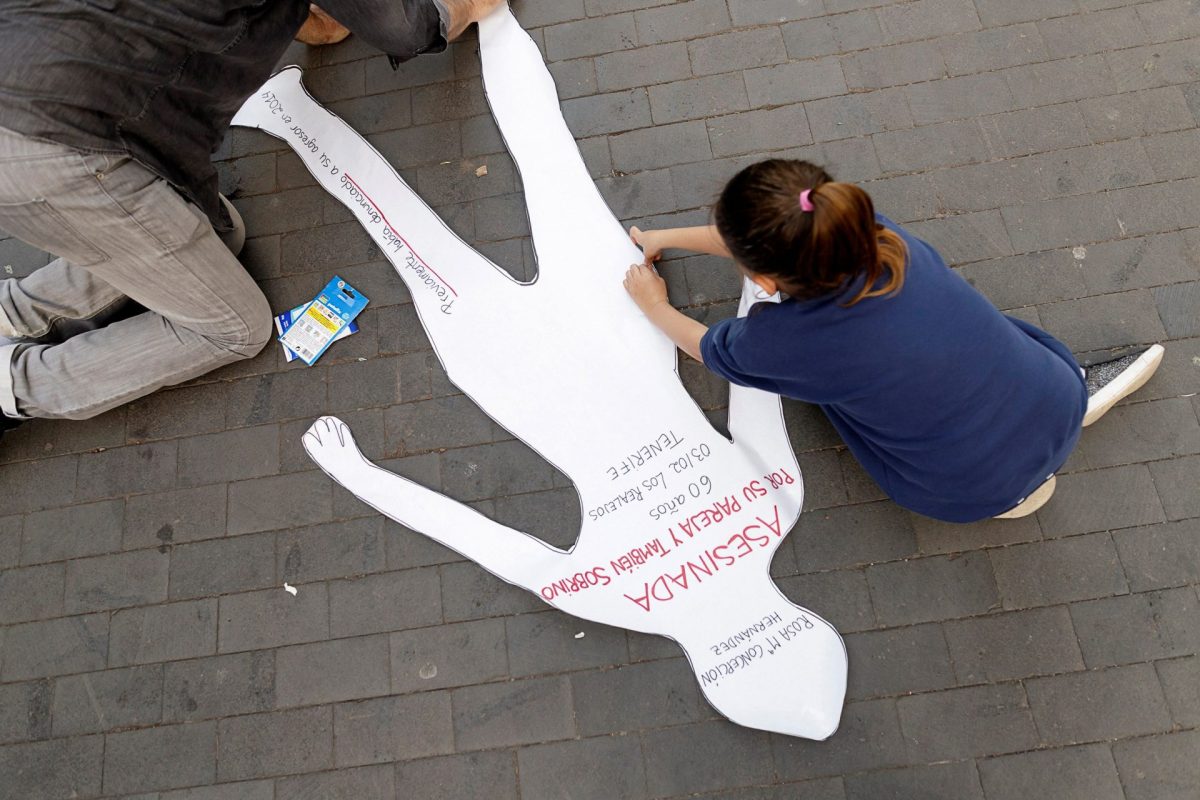 Una niña sobre una silueta en una concentración contra la violencia de género en Tenerife.