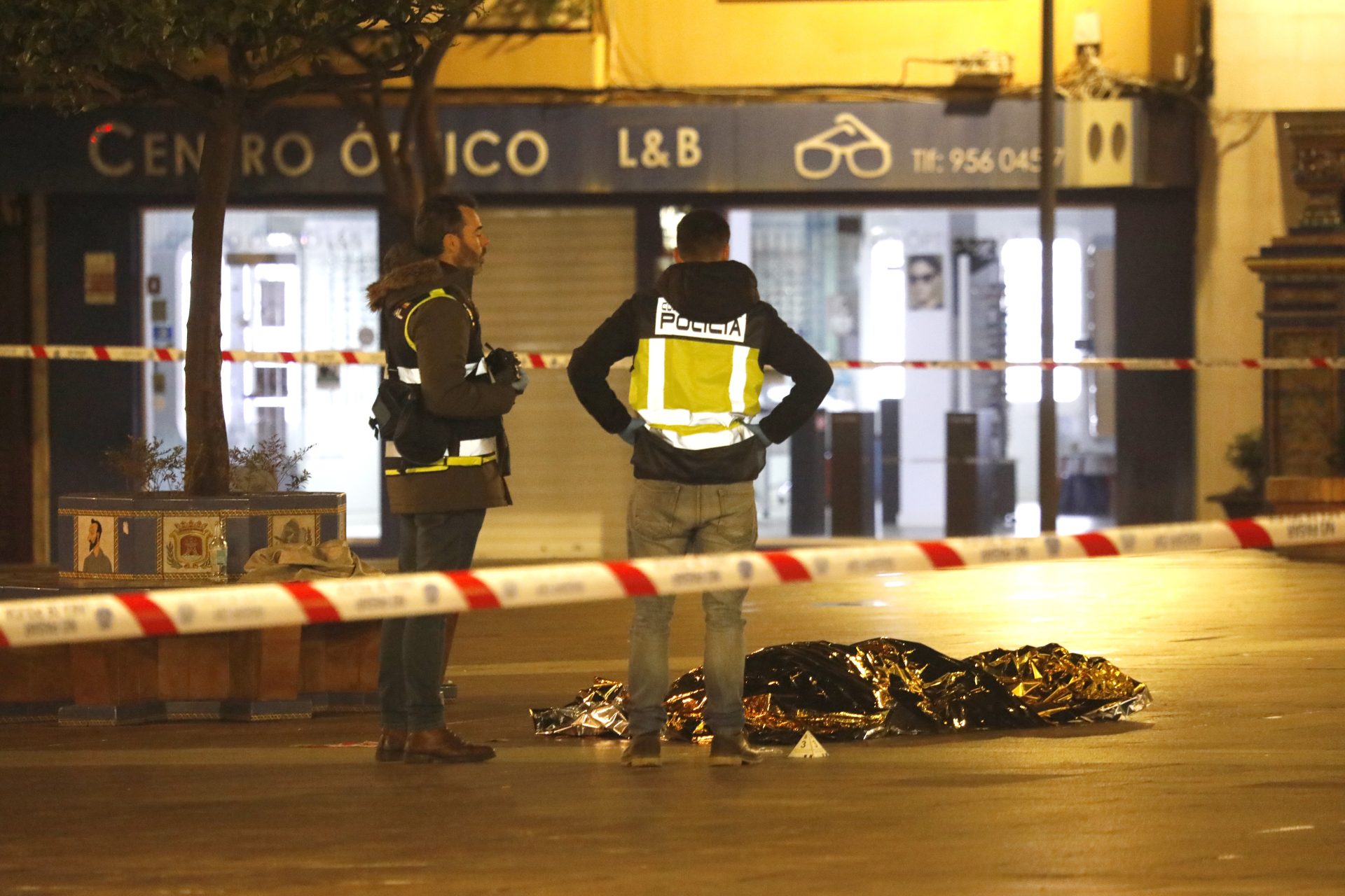Una persona yace bajo una manta térmica la Plaza Alta de Algeciras tras irrumpir un hombre en una iglesia y apuñalar mortalmente al sacristán.