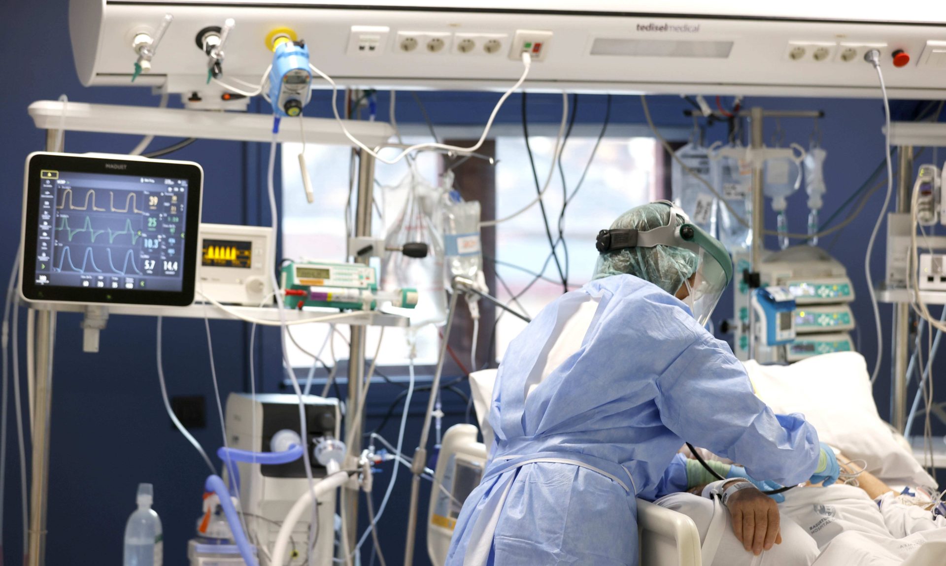 Una enfermera de un hospital trata a un paciente infectado por covid, cuyas hospitalizaciones en 2020 en España costaron 1.200 millones.