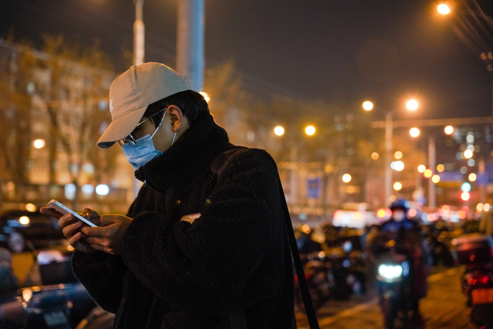 Un hombre usa su móvil mientras lleva una mascarilla para protegerse del covid en Pekín, China, país que según la OMS no ha facilitado las cifras completas sobre los muertos por esta enfermedad.
