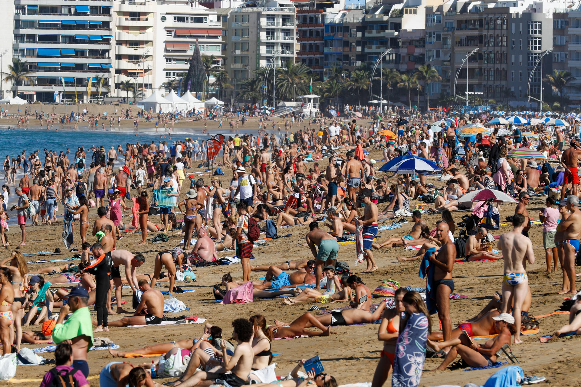 Numerosas personas aprovechan el buen tiempo, con sol y excelentes temperaturas en torno a 26 grados centígrados, para pasar el día de Navidad en la playa de Las Canteras de Las Palmas de Gran Canaria. EFE/ Elvira Urquijo A.