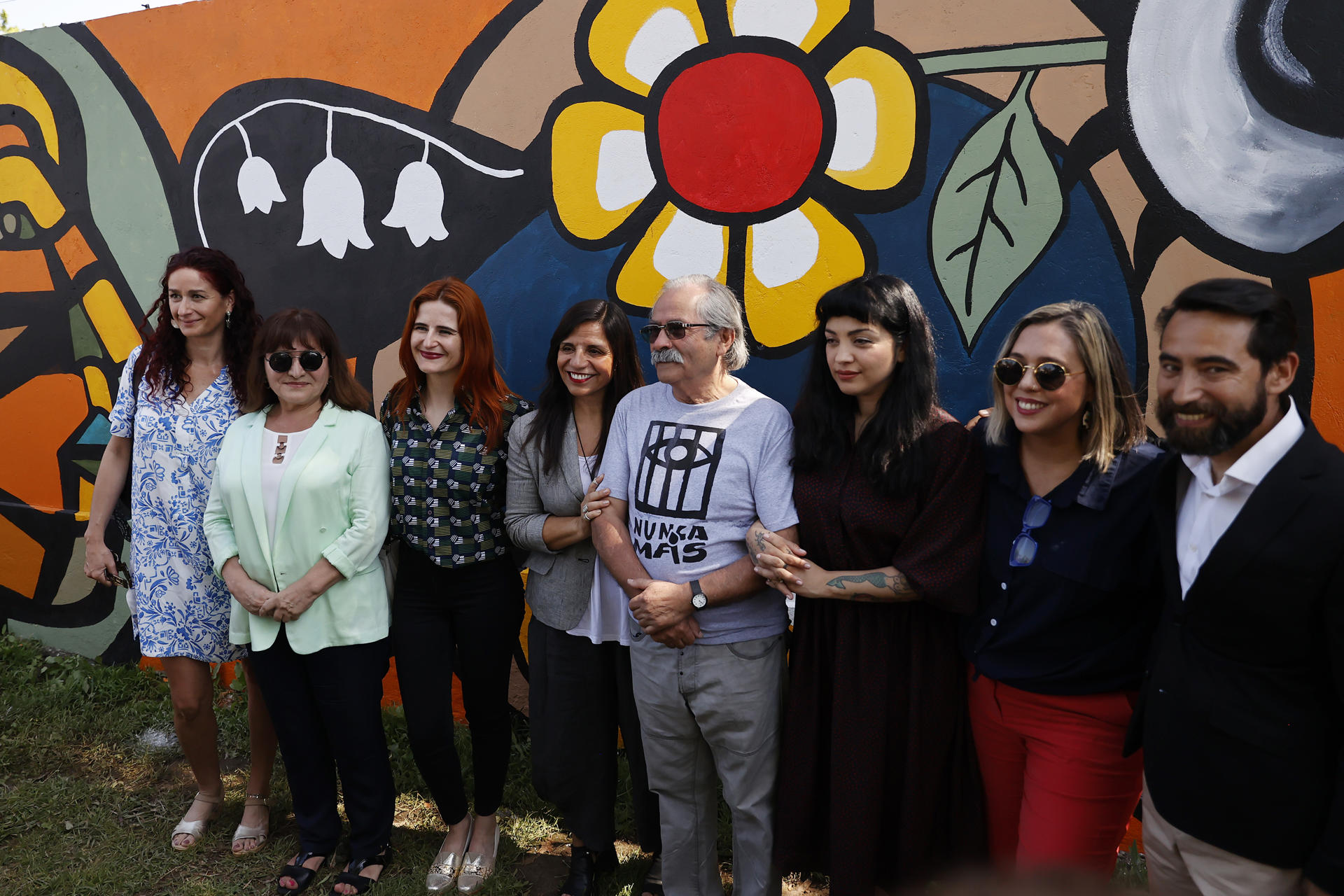 Los artistas Mon Laferte (3d) y Alejandro "Mono" González (c) posan junto a otras personas durante la inauguración de su mural al interior del Estadio Nacional, hoy, en Santiago (Chile). EFE/Elvis González