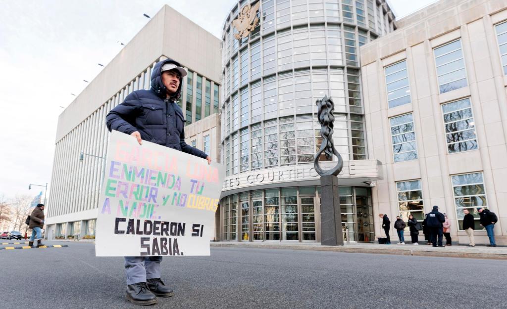 Un hombre sostiene un cartel en el tribunal federal donde se llevará a cabo el juicio a Genaro García Luna, exsecretario de Seguridad Pública de México, en el distrito de Brooklyn, en Nueva York (EE.UU.), este 17 de enero de 2023. EFE/EPA/Justin Lane
