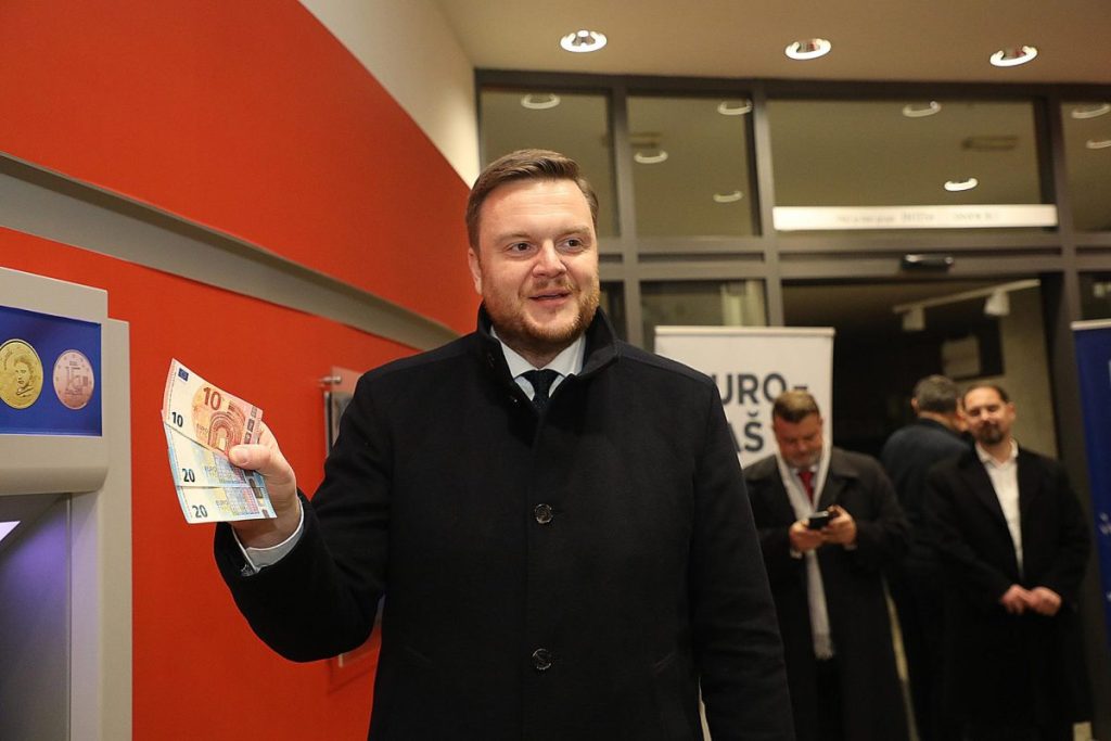 El ministro de Finanzas de Croacia, Marko Primorac, con los primeros billetes en euros en un cajero automático en Zagreb, Croacia