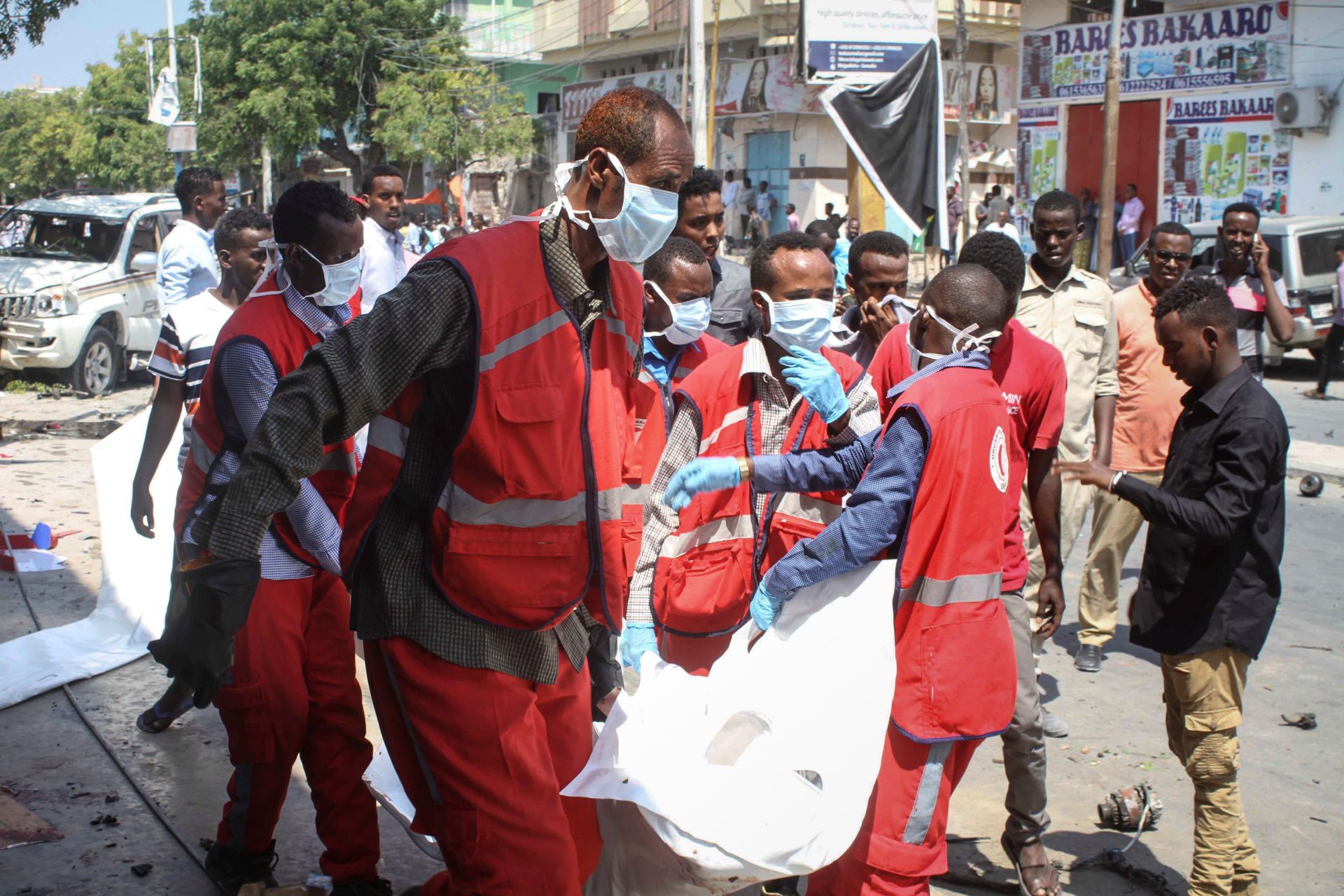 Médicos somalíes trasladan el cadáver de una víctima tras la explosión de un coche bomba.