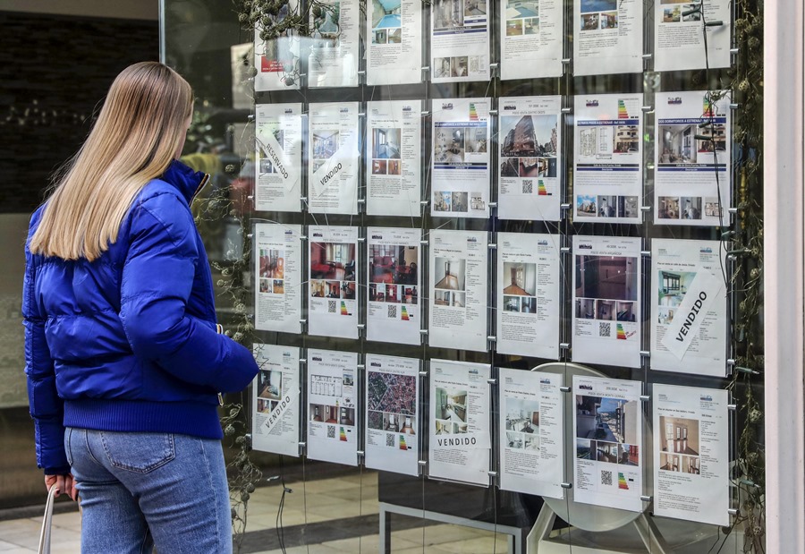 Una mujer mira los carteles en una inmobiliaria. El alquiler de habitaciones se pone de moda