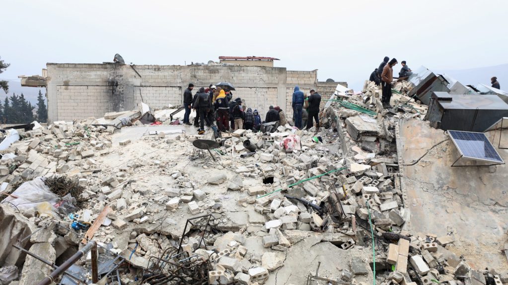 Civiles y equipos de rescate trabajan en los restos de edificio derrumbado en la ciudad de Armanaz, en la provincia siria de Idlib. 