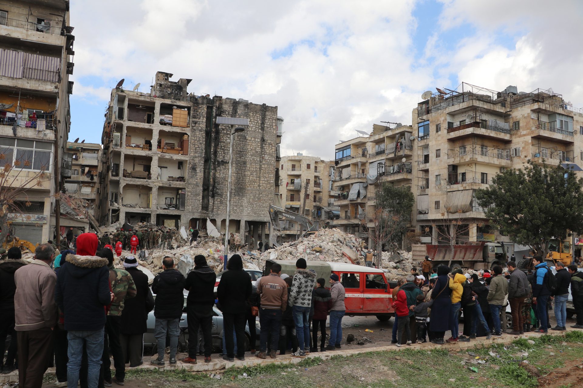 Varias personas ven los trabajos de rescate entre las ruinas en el distrito de Masharqa en Alepo, Siria.