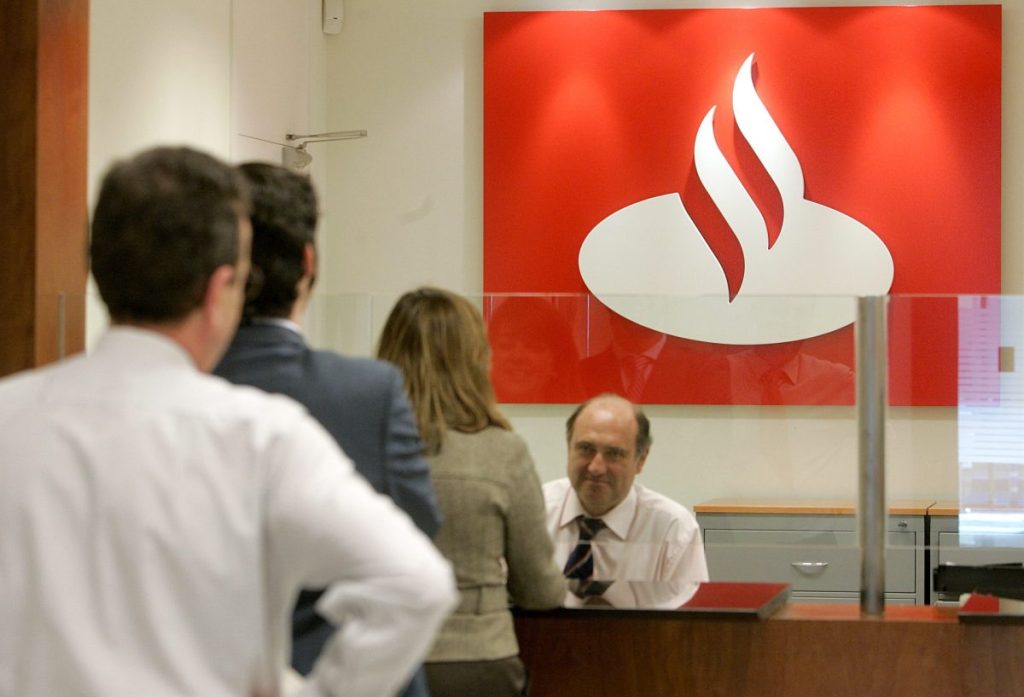 Un empleado atiende a los clientes de una oficina del Banco Santander en una imagen de archivo