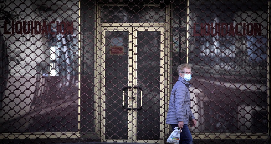 Una mujer pasea junto a un negocio cerrado en A Coruña. Los concursos de acreedores crecieron