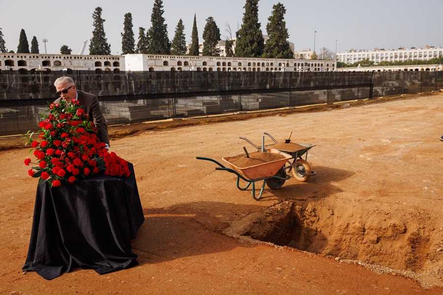 Uno de los familiares de las víctimas con un ramo de flores durante el acto simbólico de cierre de la fosa de Pico Reja, en Sevilla. 