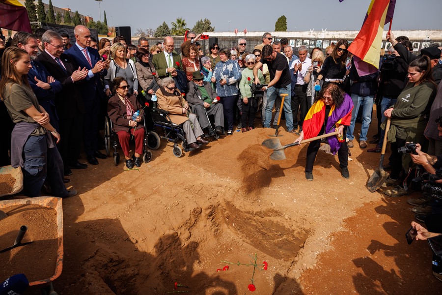 Uno de los familiares de las víctimas echa tierra durante el acto simbólico de cierre de la fosa Pico Reja, en Sevilla.