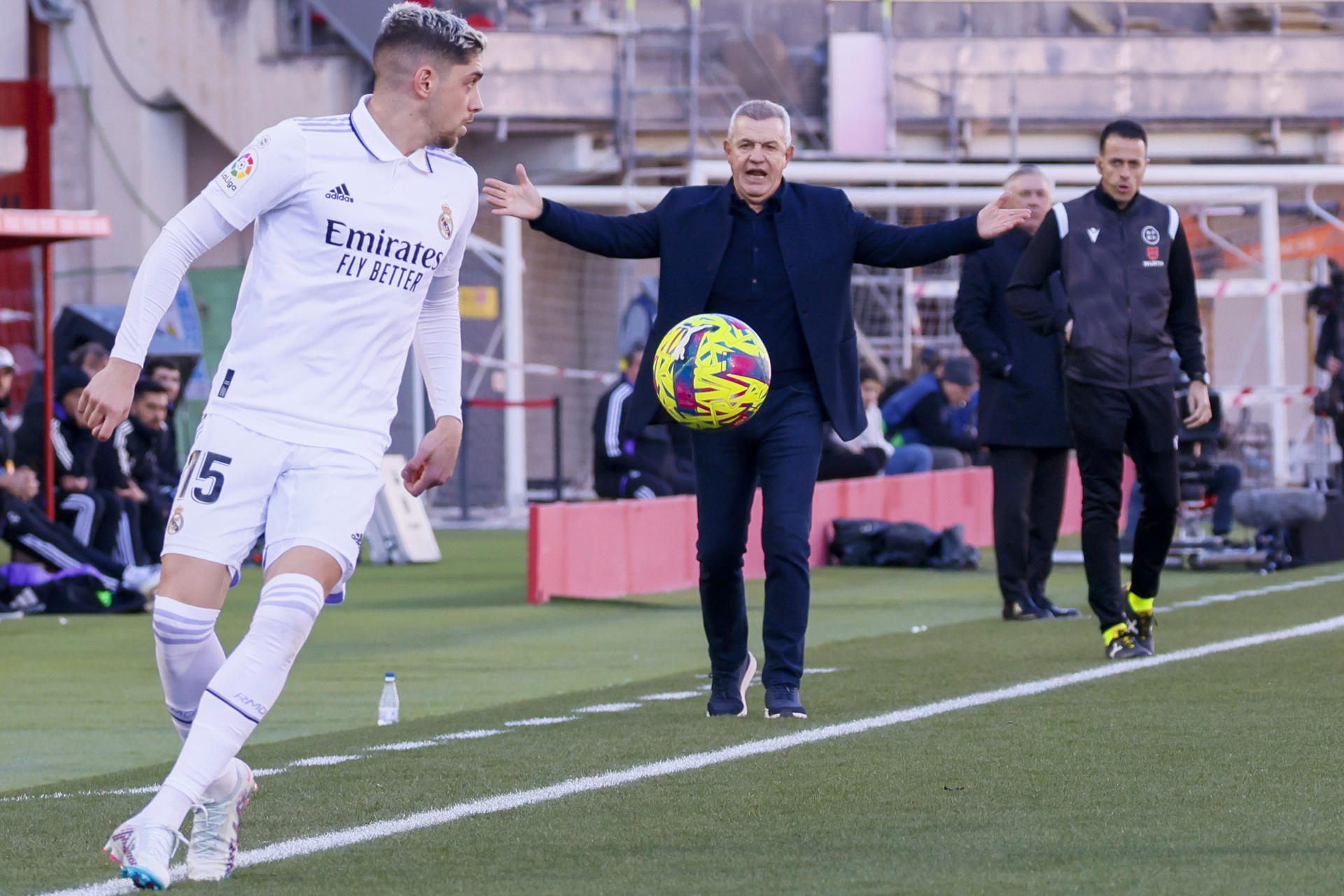 El centrocampista del Real Madrid Fede Valverde (i) pasa delante del entrenador del Real Mallorca Javier Aguirre (c) durante el Partido de La Liga en el estadio de Son Moix.- EFE/CATI CLADERA