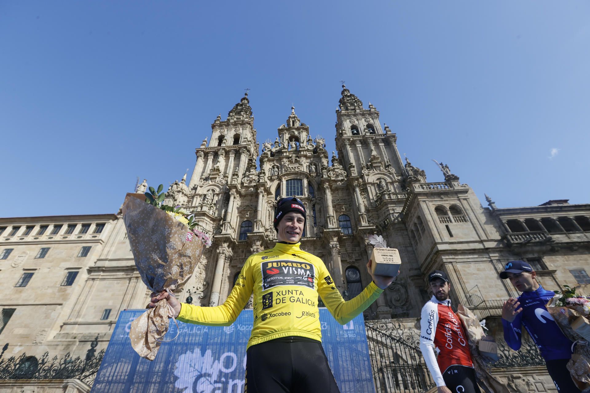 El ciclista danés Jonas Vingegaard celebra su victoria en el podio tras la etapa final de la carrera ciclista O Gran Camiño en Santiago de Compostela. EFE/ Lavandeira