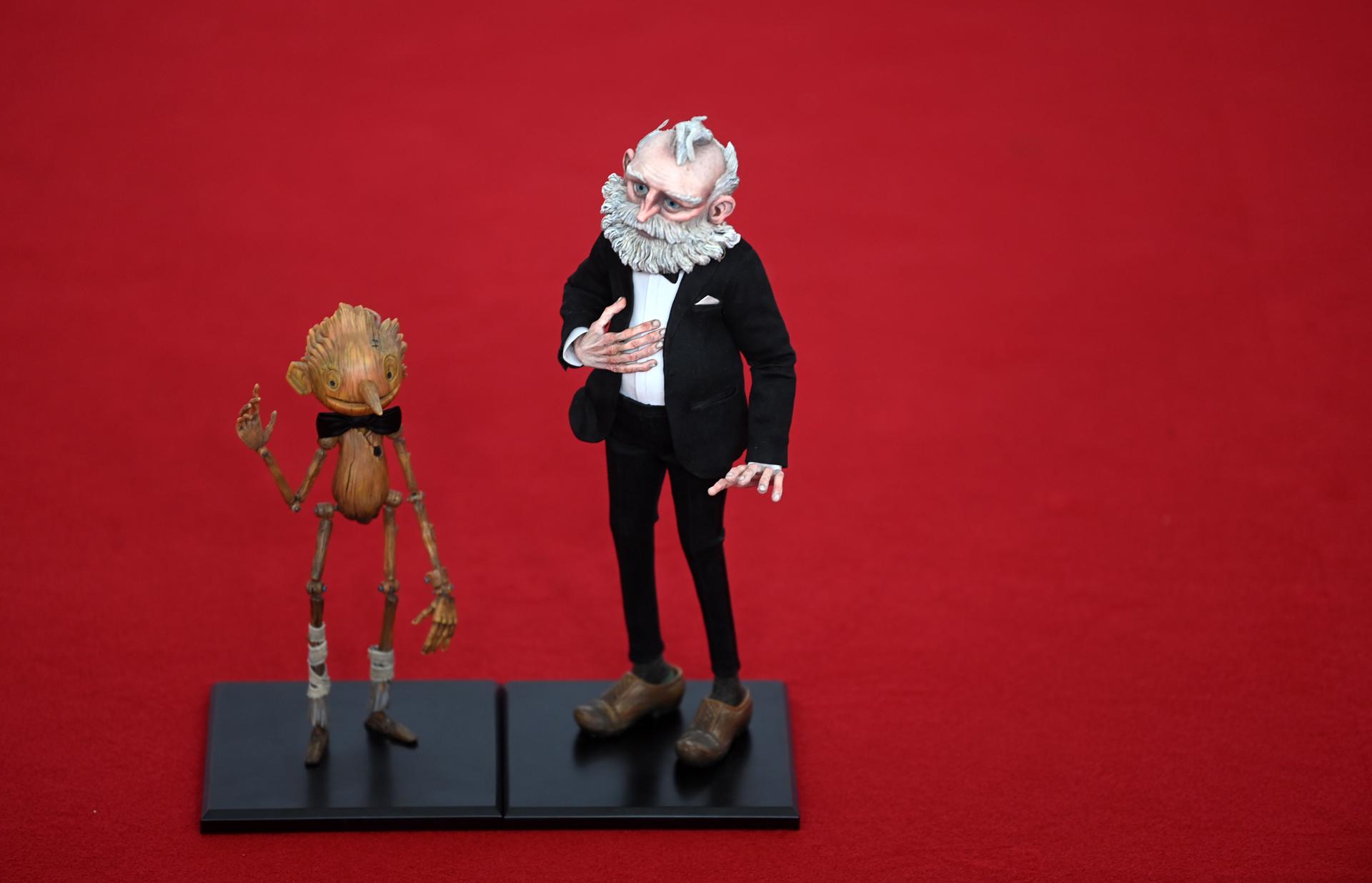 Muñecos de los personajes protagonistas de la película "Pinocchio", de Guillermo del Toro, sobre la alfombra roja de la ceremonia de entrega de los Premios Bafta, de Londres, donde la cinta ha sido galardonada como mejor filme de animación. EFE/EPA/Neil Hall