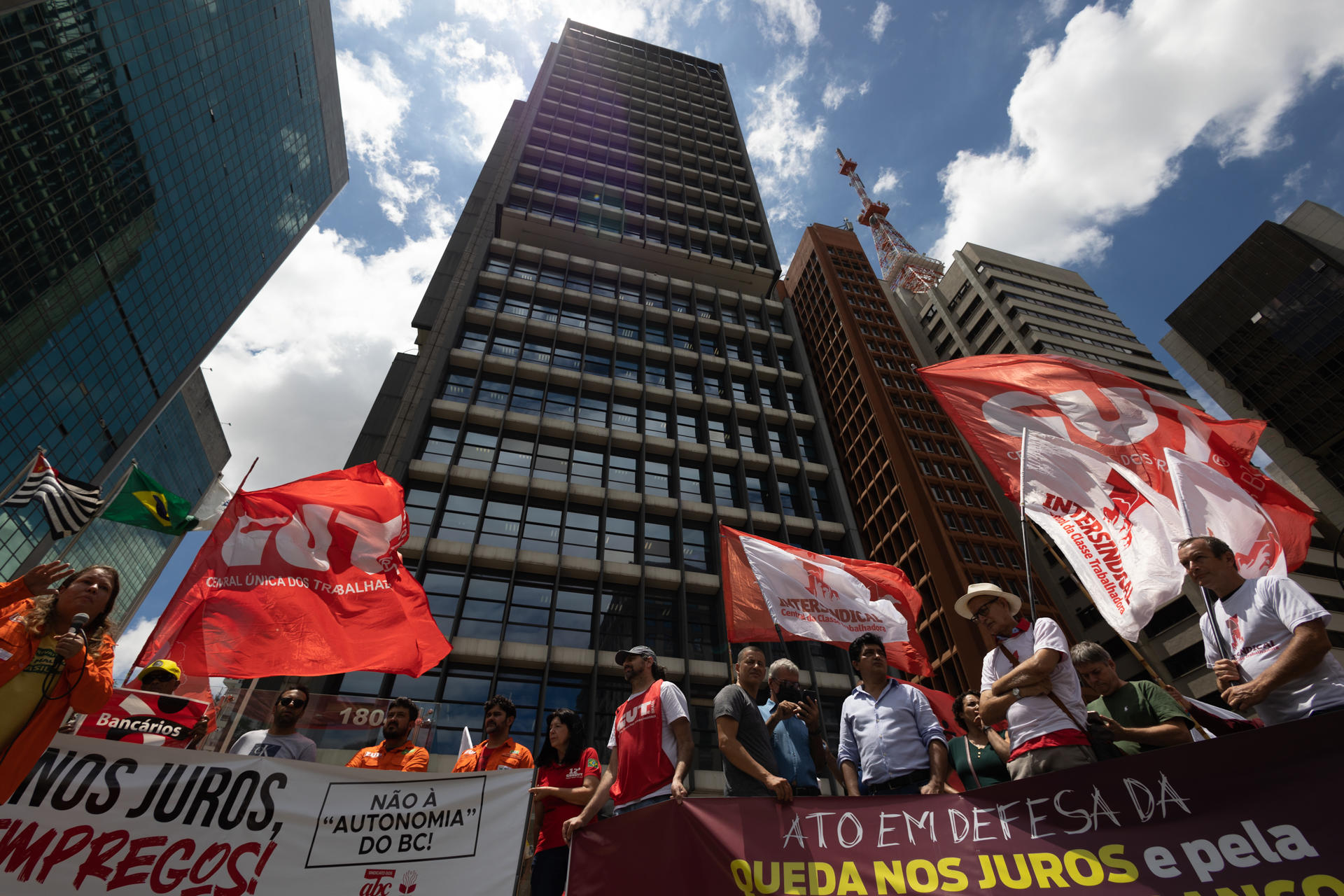 Un grupo de manifestantes, de movimientos sindicales, protestan para pedir bajas en la tasa de tipos de interés, que está en el 13,75%, el nivel más alto desde 2006, hoy en la sede del Banco Central en São Paulo (Brasil). EFE/ Isaac Fontana