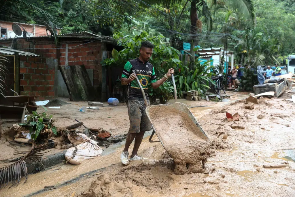 Habitantes de la zona más golpeada por las fuertes lluvias trabajan recogiendo escombros, el 20 de febrero de 2023, en la ciudad de Sao Sebastiao en el litoral del estado de Sao Paulo (Brasil). EFE/Sebastião Moreira

